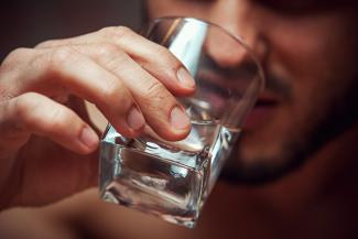A person drinking alcohol from a glass