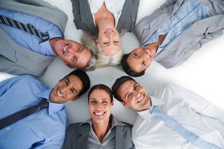 Image: People in a team building exercise at work lying on the floor and laughing