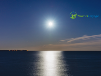 A picture of a moon shining over a body of water 