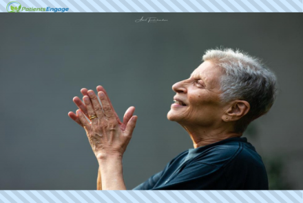 Side view of a woman with short hair and rheumatoid arthritis holding her hands together  