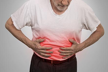 Image: Stock pic of a man in a white t-shirt holding is tummy which is marked in red as affected body part