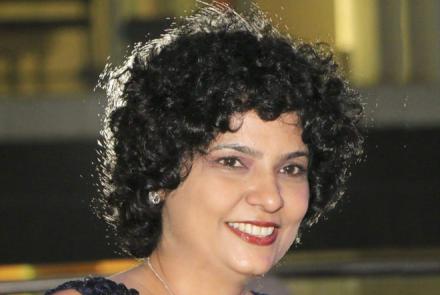 Head shot of Urvi Sabnis, a breast cancer survivor smiling at the camera  